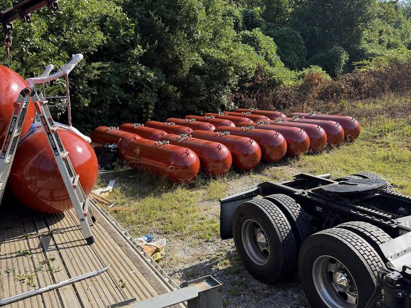 A new truckload of propane tanks being unloaded by crane at the yard