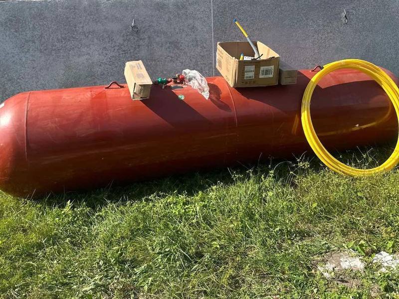 A 500 gallon tank delivered to a job site with regulators and a coil of yellow PE gas pipe